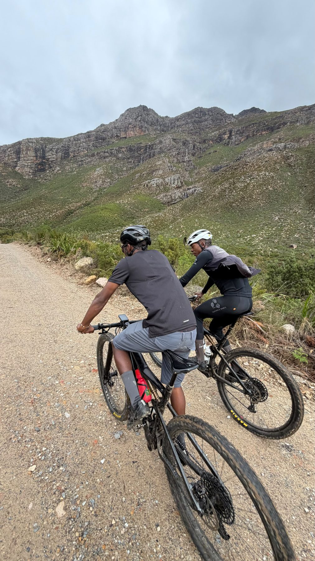 Guided riders climbing a mountain gravel road in the Cape Winelands