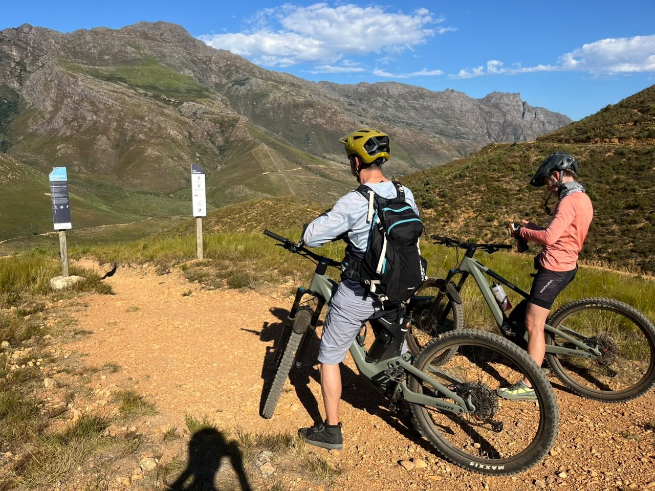 Two mountain bikers riding a gravel climb through a Cape mountain pass near Stellenbosch